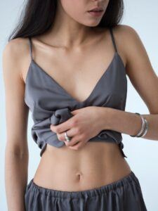 Crop young woman demonstrating muscular torso