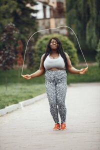 Woman in Gray Top and Leggings Skipping Rope