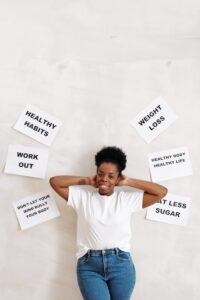 Woman Leaning on Wall Between Food Related Slogans