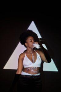 A Woman in White Bralette Drinking Milk