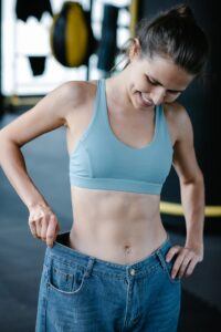 Athletic Woman Trying on Old Jeans