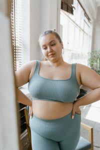 Woman in Teal Sports Bra and Brown Leggings getting ready to begin the weight loss programs on Mr. Fat Belly website.