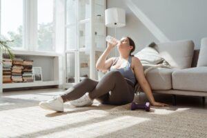 A Woman Sitting on the Floor Drinking Water